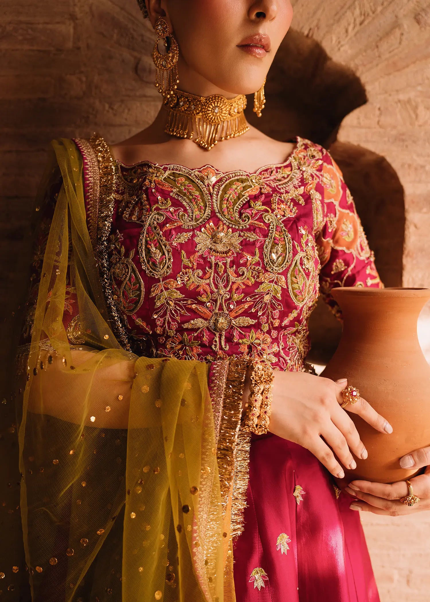 Fuschia Anaya magenta lehnga choli with traditional resham and gota embroidery paired with a contrasting olive-green dupatta for festive elegance.
